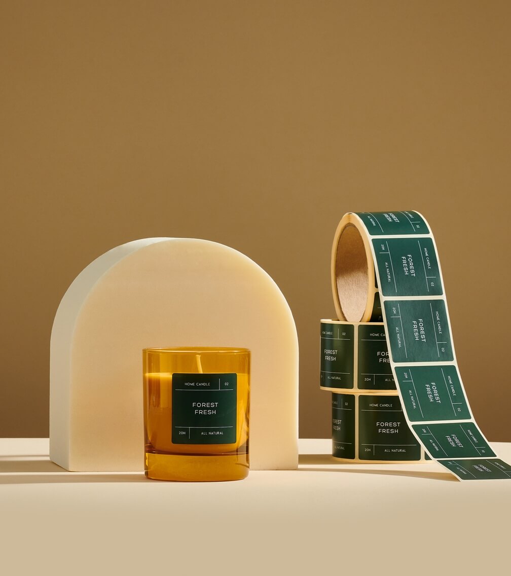 candle with printed green label and rolls of green labels