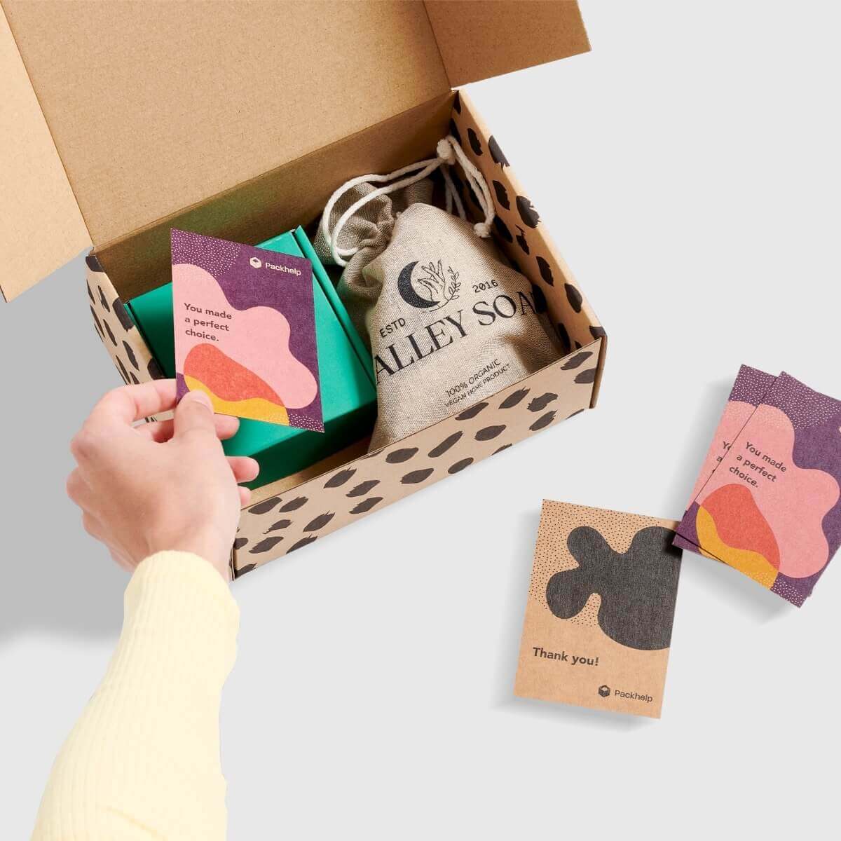 Tarjetas de agradecimiento personalizadas junto a una caja para envíos